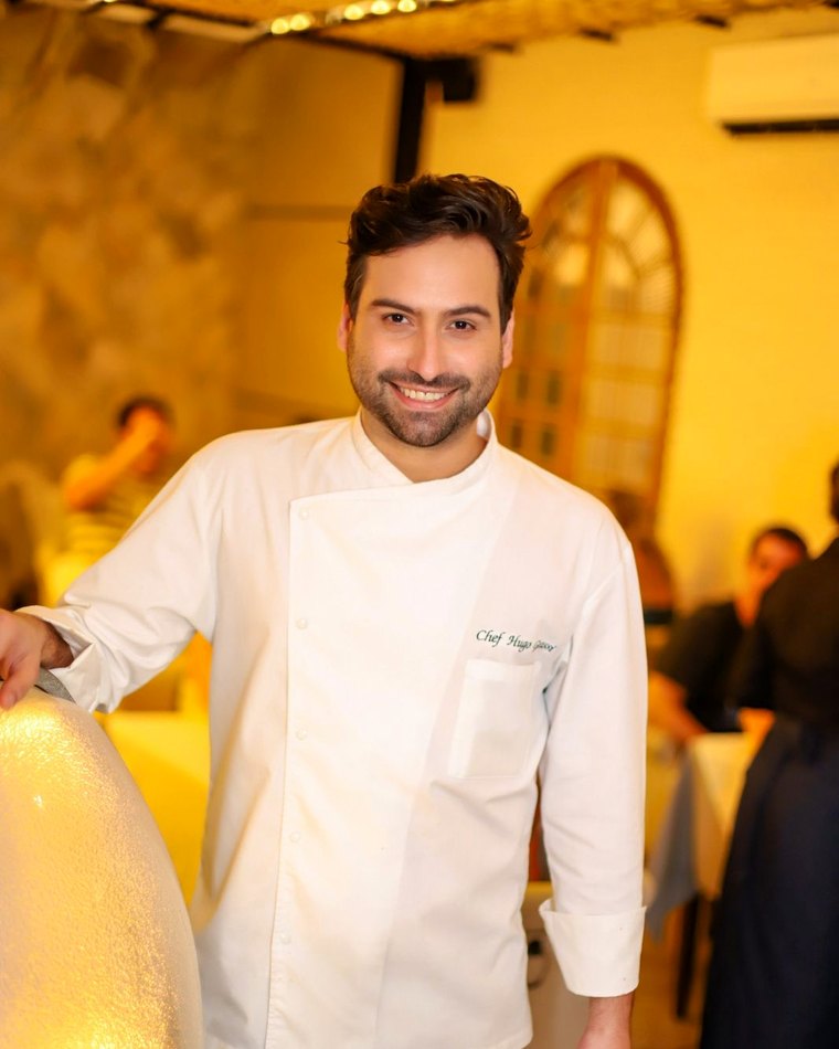 Chef Hugo Grassi empratando em cozinha profissional